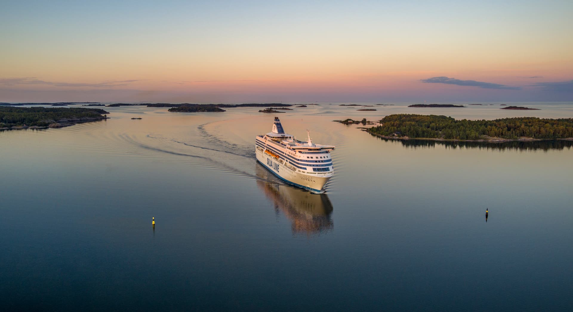 Prom Silja Line płynący o zachodzie słońca wśród wysp